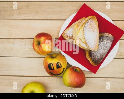 Hausgemachte Kuchen und Äpfel auf einem hölzernen Hintergrund Stockfoto