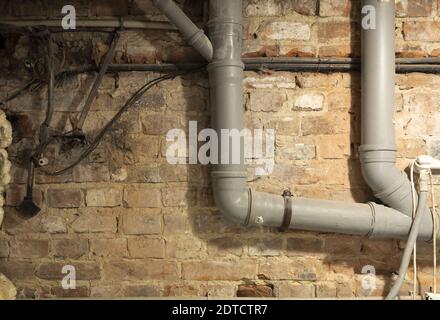 Alte Drähte im Keller. Elektrodrähte und Kanalrohre im Untergeschoss Stockfoto
