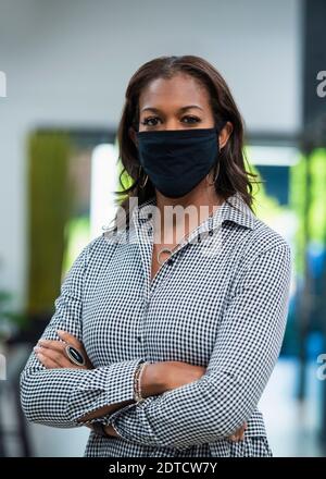 Porträt der Geschäftsfrau trägt Gesichtsmaske im Büro Stockfoto