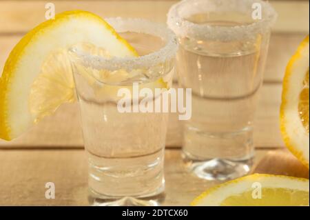 Zwei Gläser mit Tequila und Zitrone und Salz auf einem Holzhintergrund Stockfoto