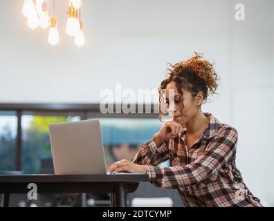 Frau sitzt mit Laptop im Büro Stockfoto