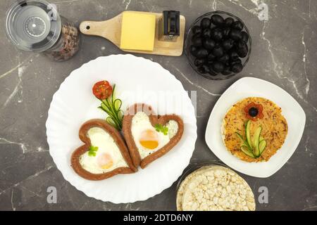 Ideen für das Frühstück mit Kindern, Rührei und Würstchen. Schnell und unterhaltsam. Gesundes Frühstück Stockfoto