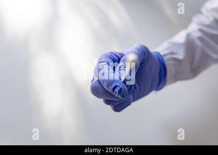 Mit Handschuhen für sterile Abstrichtupfer für COVID-Tests Stockfoto