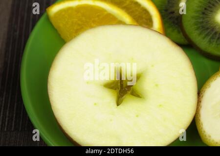 Hintergrund für Text aus Früchten. In Scheiben geschnittene Früchte und Apfel in Form eines Sterns. Apfel, Banane, Kiwi, Zitrone, Orange, Zitrus Stockfoto