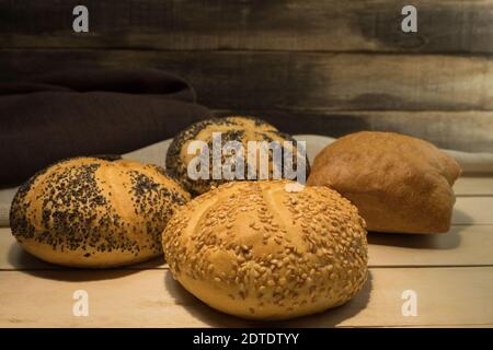 Frische und knusprige Brötchen mit Sesamsamen und Mohn. Brot wird zu Hause gebacken. Der Prozess der Herstellung von Sandwiches Stockfoto