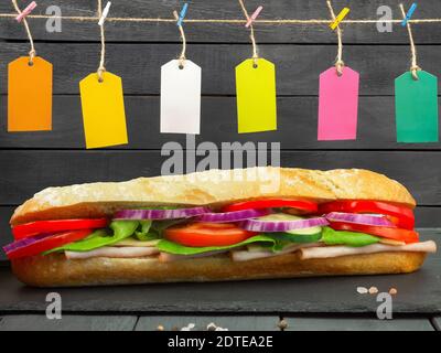 Der Prozess der Herstellung von Sandwiches. Zutaten für Sandwiches, Käse und Gemüse. Gewürfelter Käse, runder Camembert und Gouda Stockfoto