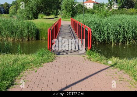 Rote Metallbrücke über den Fluss. Landschaft und Landschaft Stockfoto