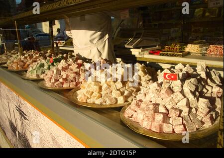 Türkische Desserts süßes Lokum aus der Nähe durch das Fenster auf der Straße. Kleine türkische Flaggen in der Mitte des Tellers der Süßigkeiten. Istanbul, Türkei. Stockfoto