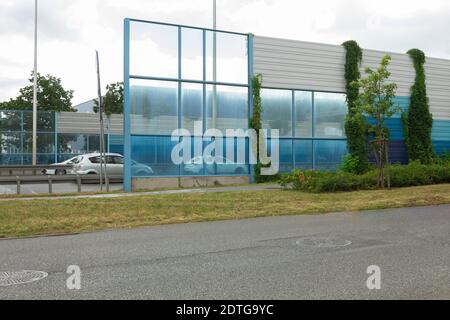 Lärmschutzzaun auf Stadtstraßen. Kletteranlage am Zaun der Lärmschutzmauer und im Hintergrund - Wohngebäude Stockfoto