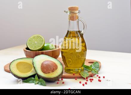 Konzept der vegetarischen Küche mit Avocado, Limetten und Olivenöl auf weißem Hintergrund. Stockfoto