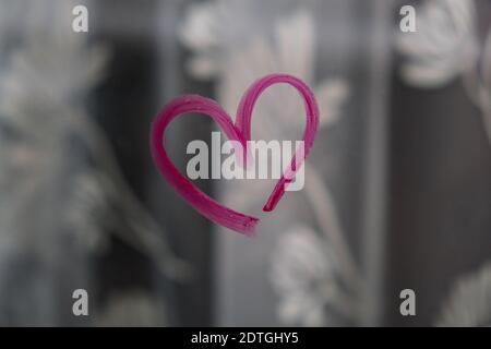 Herz auf Glas mit Lippenstift gemalt. Valentinstag. Liebe und Romantik. Herz gezeichnet von einem Lippenstift. Angezeigt. Lippenstift mit Beschriftung Stockfoto