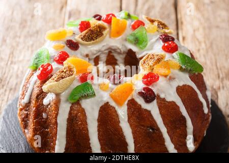 Pound Kuchen mit getrockneten Beeren und Früchten und Zuckerguss Nahaufnahme auf einem Brett auf dem Tisch. Horizontal Stockfoto