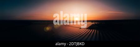 Luftaufnahme über eine moderne Solarfarm bei Sonnenaufgang in Die englische Landschaft Panorama Stockfoto