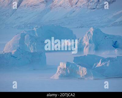 Eisberge erstarrten im Winter im nordwestlichen grönland nördlich des Polarkreises im Meereis des Uummannaq Fjordsystems. Hintergrund ist Nuu Stockfoto