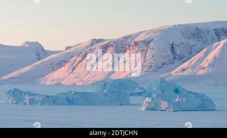Eisberge erstarrten im Winter im nordwestlichen grönland nördlich des Polarkreises im Meereis des Uummannaq Fjordsystems. Hintergrund ist Nuu Stockfoto
