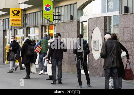 Dortmund, 18. Dezember 2020: Kunden warten auf dem Bürgersteig vor einer Filiale der Deutschen Post / DHL in Dortmund. Aufgrund der Einschränkungen der zweiten Sperrung der Corona-Pandemie dürfen nur 3 Kunden gleichzeitig in dieser Filiale bleiben. Stockfoto