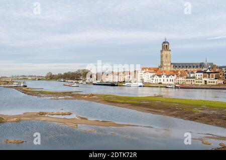 Deventer, NIEDERLANDE - 18. JANUAR 2014: Das historische Zentrum von Deventer mit der Lebuinuskirche und dem Fluss IJssel im Vordergrund. Stockfoto