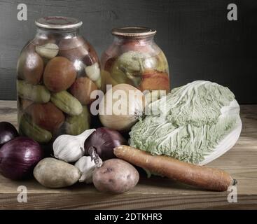 Konserven und frisches Gemüse auf einem Holzregal Stockfoto