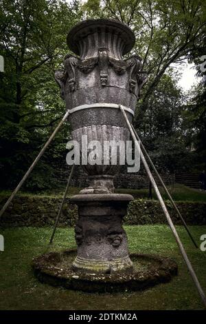 Die Skulptur einer großen dekorativen Vase unter den Pflanzen Im heiligen Wald von Bomarzo Stockfoto