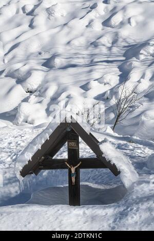 Ein schneebedecktes Kruzifix im Winter Stockfoto