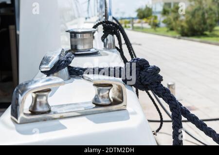 Detail eines Ankerseils auf einer Yacht. Festmachen Knoten auf dem Boot aus nächster Nähe. Versiegelungsknoten aus nächster Nähe. Bootsanlegestelle aus Edelstahl mit verknotetem Seil Mo Stockfoto