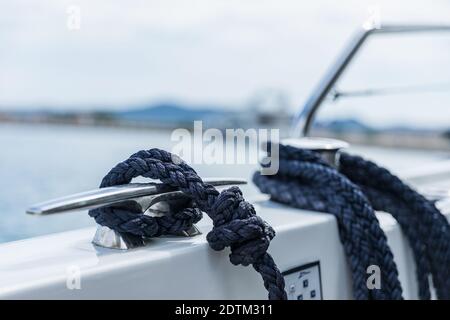 Detail eines Ankerseils auf einer Yacht. Festmachen Knoten auf dem Boot aus nächster Nähe. Versiegelungsknoten aus nächster Nähe. Bootsanlegestelle aus Edelstahl mit verknotetem Seil Mo Stockfoto