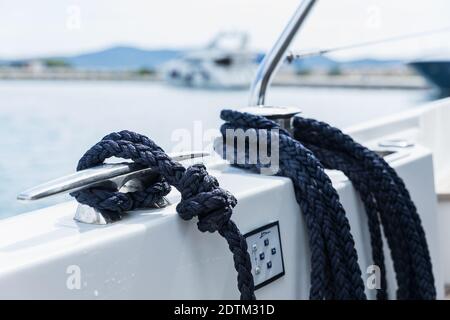 Detail eines Ankerseils auf einer Yacht. Festmachen Knoten auf dem Boot aus nächster Nähe. Versiegelungsknoten aus nächster Nähe. Bootsanlegestelle aus Edelstahl mit verknotetem Seil Mo Stockfoto