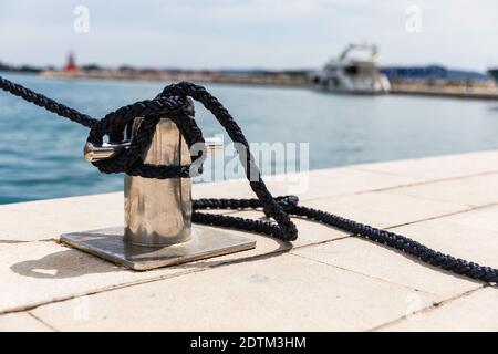 Detail eines Ankerseils auf einer Yacht. Festmachen Knoten auf dem Boot aus nächster Nähe. Versiegelungsknoten aus nächster Nähe. Bootsanlegestelle aus Edelstahl mit verknotetem Seil Mo Stockfoto