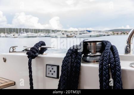 Detail eines Ankerseils auf einer Yacht. Festmachen Knoten auf dem Boot aus nächster Nähe. Versiegelungsknoten aus nächster Nähe. Bootsanlegestelle aus Edelstahl mit verknotetem Seil Mo Stockfoto