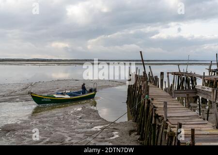 Carrasqueira, Portugal - 19. Dezember 2020: Fischer verlassen die Cais Palatifico Fischerdocks in Carrasqueira am Abend bei Ebbe, um zu wor zu gehen Stockfoto