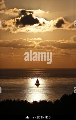 Pyla-sur-Mer (Südwestfrankreich): Blick von der Spitze der Pilat-Düne und Sonnenuntergang über der Bucht von Arcachon. Segelboot durch einen Lichtstrahl auf der Arg Stockfoto