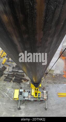 Hochwinkelansicht eines Kranwagens mit dem Ausleger im Vordergrund auf einer Baustelle. Vertikales Format Stockfoto