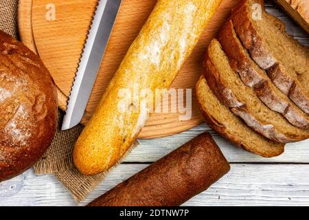 Verschiedene Brotsorten auf einem hellen Tisch im provenzalischen Stil. Frisches knuspriges Toastbrot, Draufsicht Stockfoto