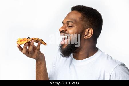 Afrikanischer Mann, Der Pizza Isst, Weißer Hintergrund, Seitenansicht Stockfoto