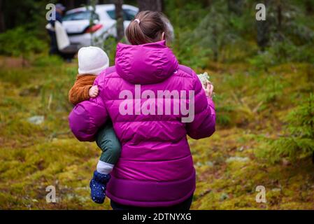 GULBENE, LETTLAND. Dezember 2020. Eine Frau hält Baby Kleinkind in den Händen. Stockfoto
