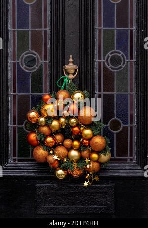 Brighton UK 22. Dezember 2020 - Weihnachtskranz Dekorationen hängen An den Türen im Queens Park Bereich von Brighton Credit Simon Dack / Alamy Live News Stockfoto