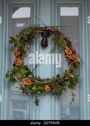 Brighton UK 22. Dezember 2020 - Weihnachtskranz Dekorationen hängen An den Türen im Queens Park Bereich von Brighton Credit Simon Dack / Alamy Live News Stockfoto