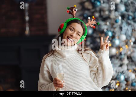 Schöne junge Frau mit einem Glas Champagner zu Hause. Stockfoto