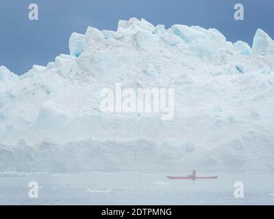 Kajak im Nebel vor riesigen Eisbergen. Ilulissat Icefjord auch als Kangia oder Ilulissat Kangerlua in Disko Bay. Der eisfjord ist als UNESCO wo Stockfoto