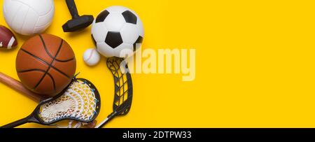 Verschiedene Sportgeräte wie Fußball, Volleyball, Baseball, american Football, Lacrosse und Hockey auf blauem Hintergrund. Draufsicht, Platz Stockfoto
