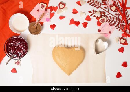 Teig für Herzkekse zum Valentinstag, Zutaten zum Backen für den Urlaub. Dekorative Herzen Draufsicht. Stockfoto