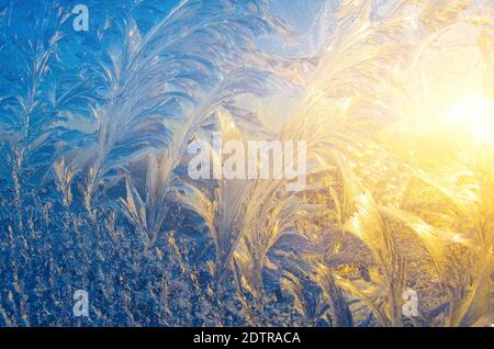 Frostige Muster auf dem Glas bei Sonnenuntergang Stockfoto