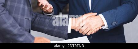 Beschnittene Ansicht von Geschäftsleuten schütteln Hände miteinander, Banner Stockfoto