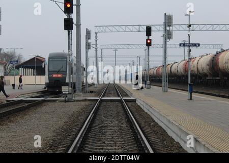 Bahnhofslandeplattform und Zug auf den Gleisen am Nachmittag. Stockfoto