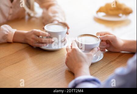 Liebevolles junges Paar auf Datum im Café, Kaffee trinken zusammen, beschnitten Blick auf die Hände Stockfoto
