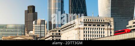 Londons moderne Skyline bei Sonnenaufgang mit roten Bussen Das Panorama der Themse Stockfoto