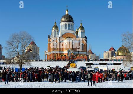 Menschen schwimmen in einem Eisloch während des Dreikönigsfestes auf dem Fluss Dnjepr, Sviato-Pokrovskiy Kathedrale auf einem Hintergrund. Januar 19, 2019. Kiew, Ukr Stockfoto