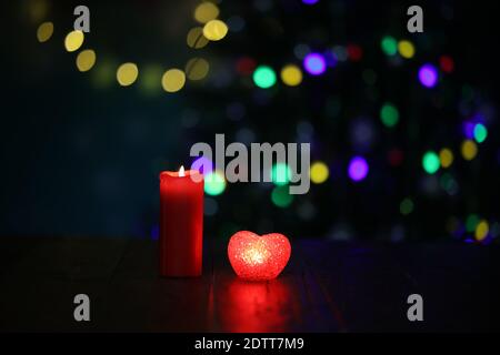 Weihnachtskomposition mit brennender Kerze und schönem Bokeh im Hintergrund. Stockfoto
