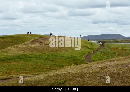 Nicht erkennbare Menschen an der Küste rund um den Teich Stachholstjorn mit Pseudo Craters - Naturdenkmal in der Nähe von Lake Myvatn im Norden Island in su Stockfoto