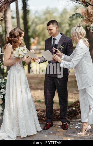 Der Moment, in dem der zeremonielle Meister die Eide gibt Das Brautpaar Stockfoto